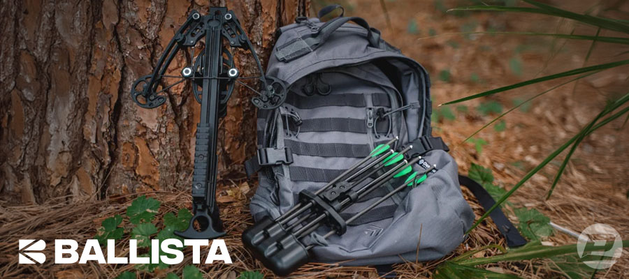 Ballista Bat Compound Crossbow leaning against a tree alongside a backpack and quiver