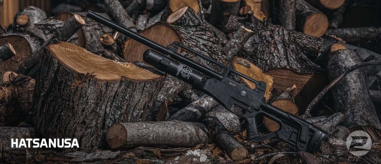 Hatsan Blitz full auto air rifle propped up on a pile of wood