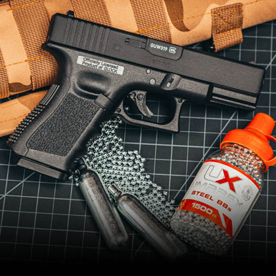 glock 19 gen 3 laying beside 2 co2 cartridges and steel bbs
